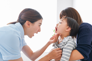 口の中をチェックしてもらう子ども